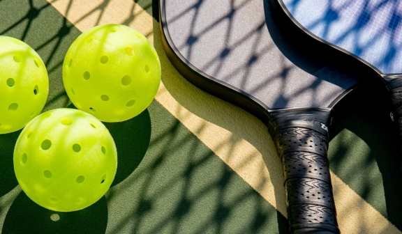 Closeup of racquets next to balls