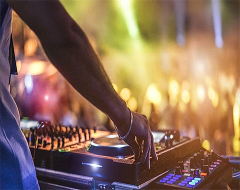 A dj playing to a crowd of people at night