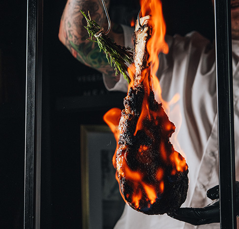 Swinging Wagyu Tomahawk Steak on fire