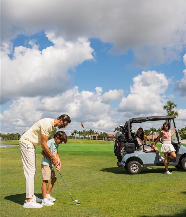 Father teaching son golf