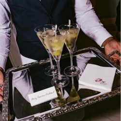 Cocktail server holding a tray of martinis