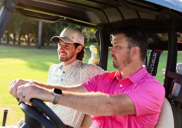 Two golfers driving in golf cart