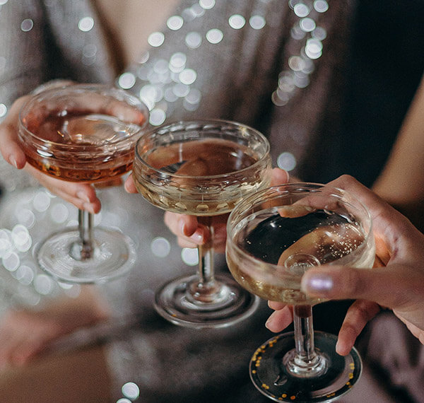Cocktails clinking for cheers from guests in formal wear