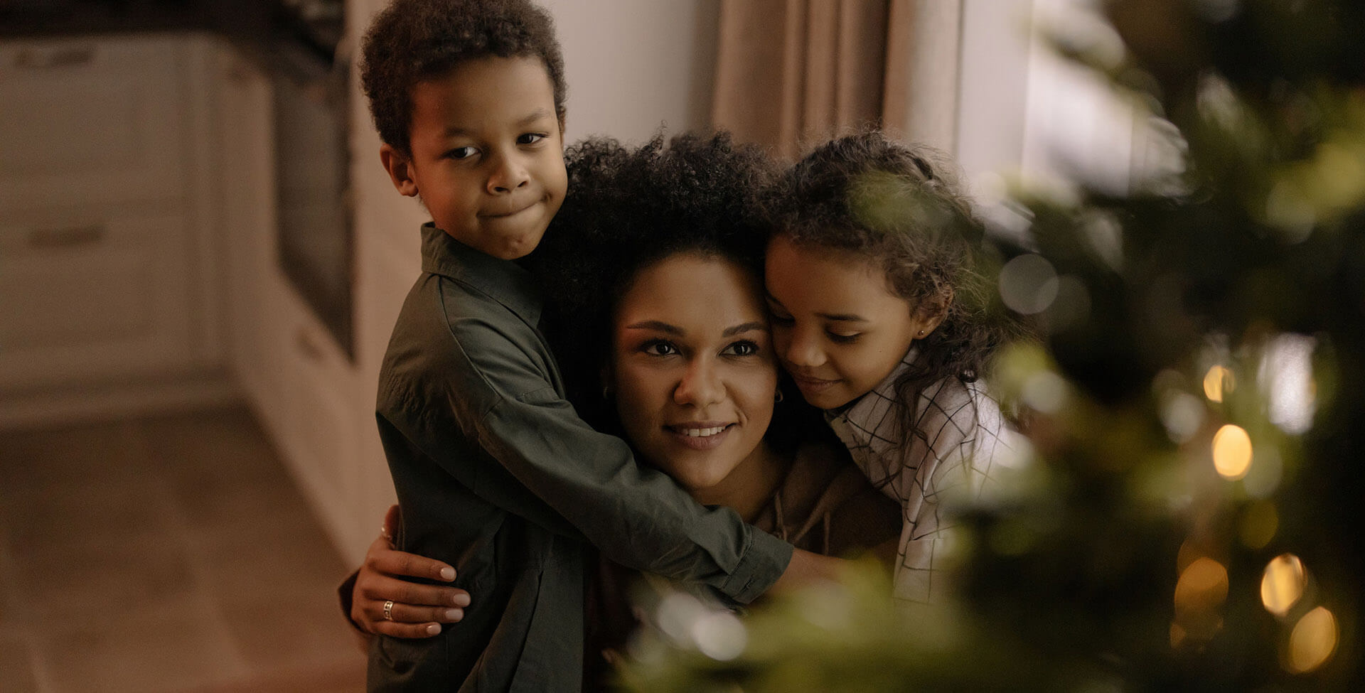 Family hugging together by a Christmas tree